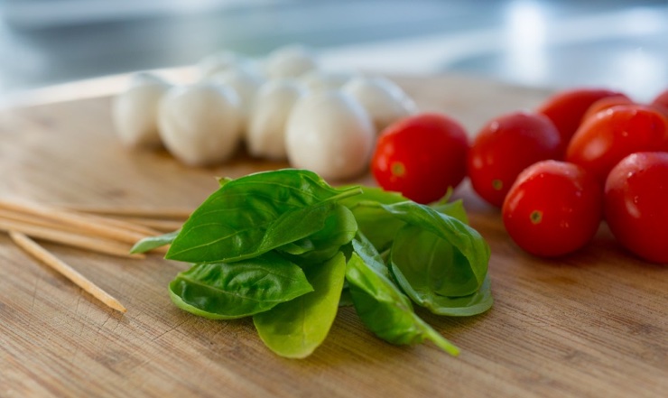 High res photo of food for a caprese salad - fresh basil, tomato and mozzarella