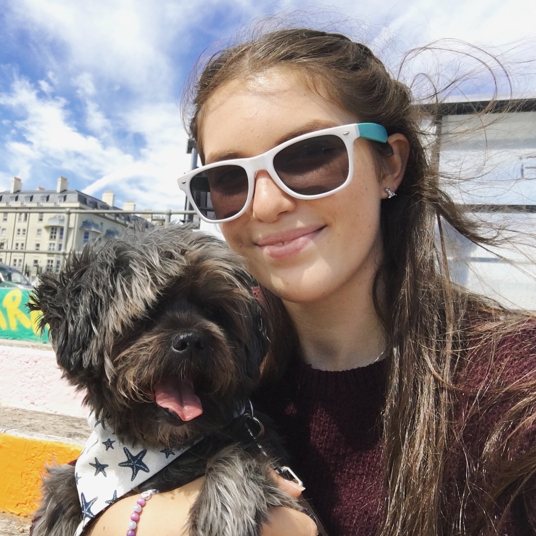 Chloe holding her dog, Tommi, outdoors