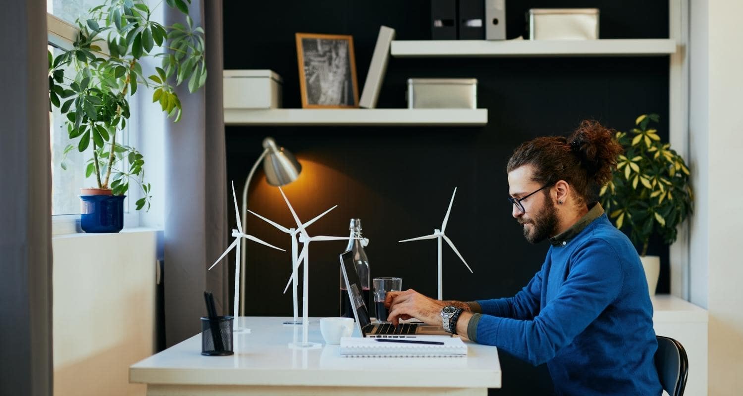 A person sitting at their desk surrounded by mini wind turbines