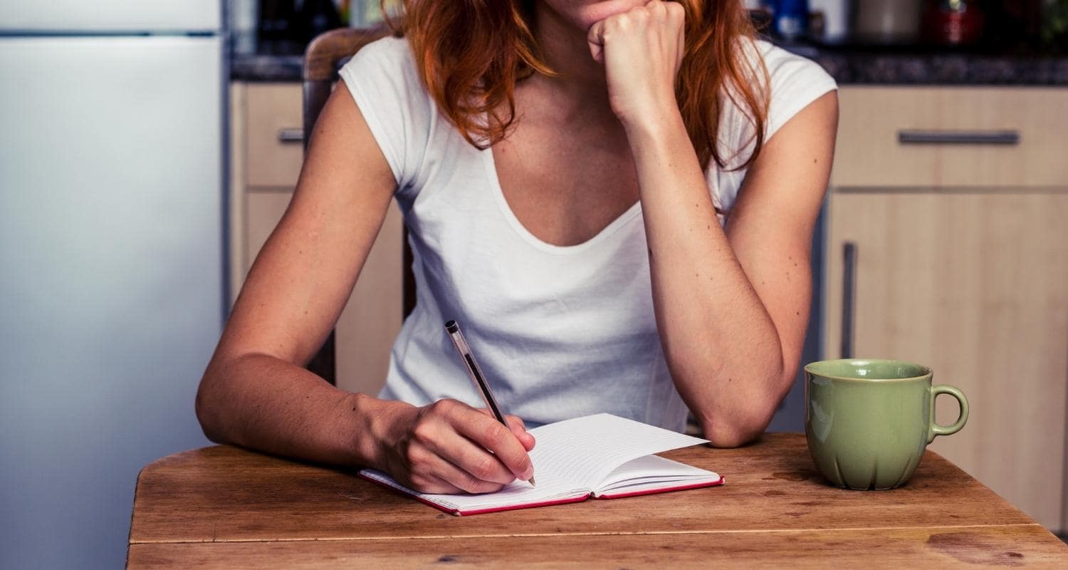 A Person Writing at Their Desk and Thinking