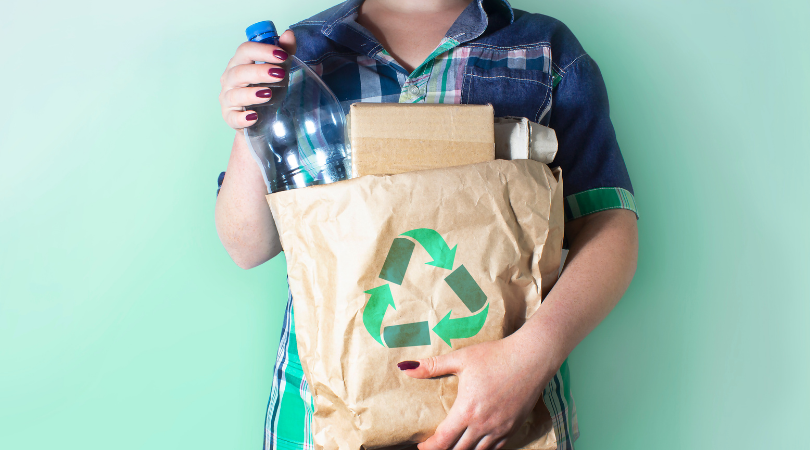 A person carrying a small bag of recycling