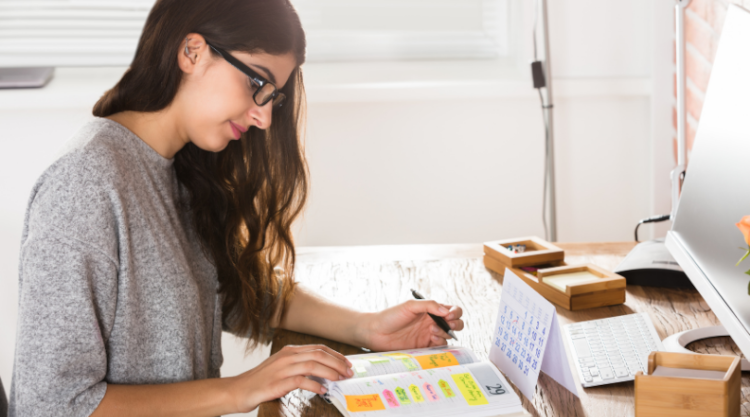 A person planning dates in a journal at their desk