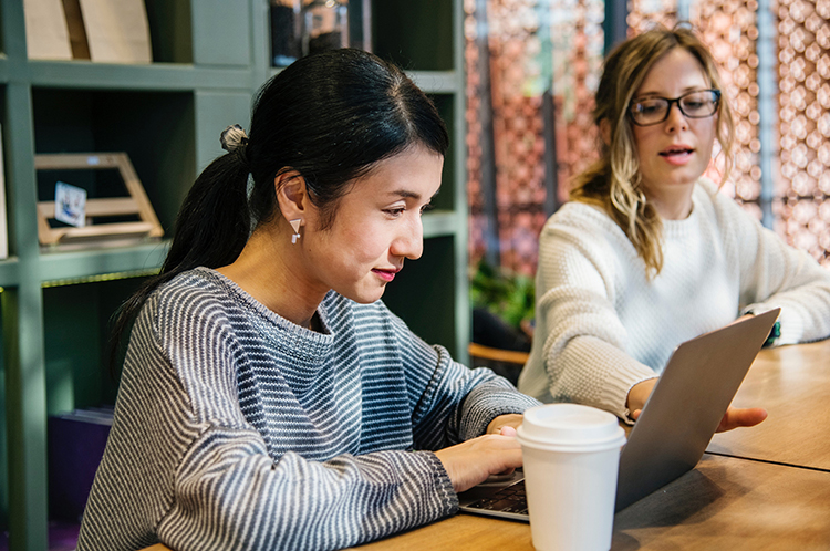 two people working at a laptop