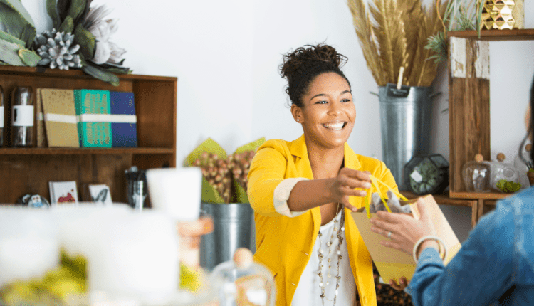 A brightly dressed small business owner helping a customer with a purchase