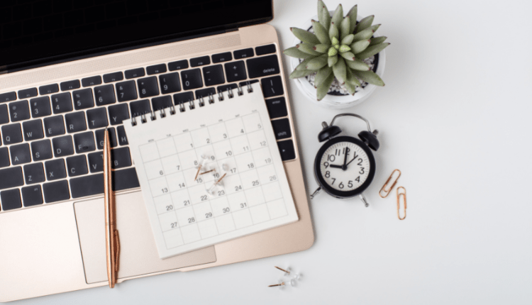 A calendar and pen resting atop a laptop keyboard